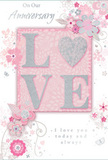 This anniversary card presents a gentle celebration of enduring romance, using soft pastel pinks, pearly whites, and silvery greys to conjure a feeling of intimacy and warmth, like a quiet evening at home in Canonbury. At its centre, the word LOVE stands in raised, soft glitter, each letter defined yet delicate, with the O reimagined as a shimmering heart shape rendered in textured silver. This heart catches and scatters light, adding a focal point that naturally draws the eye and the fingertips. Around the glittered word, a halo of flowers in blush, mauve, and pale ivory unfurls, their petals painted with a watercolor softness that blends gently into the pink-toned background. Fine lines trace stems and leaves that curl and flow, evoking the fluid movement of a florist composing a romantic arrangement on a workbench not far from Canonbury's leafy streets. Tiny flourishes-petals in mid-fall, swirling tendrils, and subtle butterfly silhouettes-add a sense of motion, suggesting a soft breeze moving through an English spring garden. The overall background remains a calm, dusty pink, providing a soothing canvas that allows the silver accents and floral detailing to stand out without ever feeling loud. Elegant script across the front bears the words On Our Anniversary and I love you today and always, the lettering slender and refined, harmonising with the gentle artwork. Together, these elements create the impression of a lovingly composed paper bouquet, ideal to accompany fresh anniversary flowers delivered locally to a Canonbury doorstep, capturing years of shared moments in one tender, beautifully arranged design.
